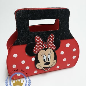 May include: A red Minnie Mouse-themed handbag with white polka dots and a black handle covered in glitter. The bag features a Minnie Mouse face and bow. The text "Royal Baby Baby Us" is printed on the bottom left.