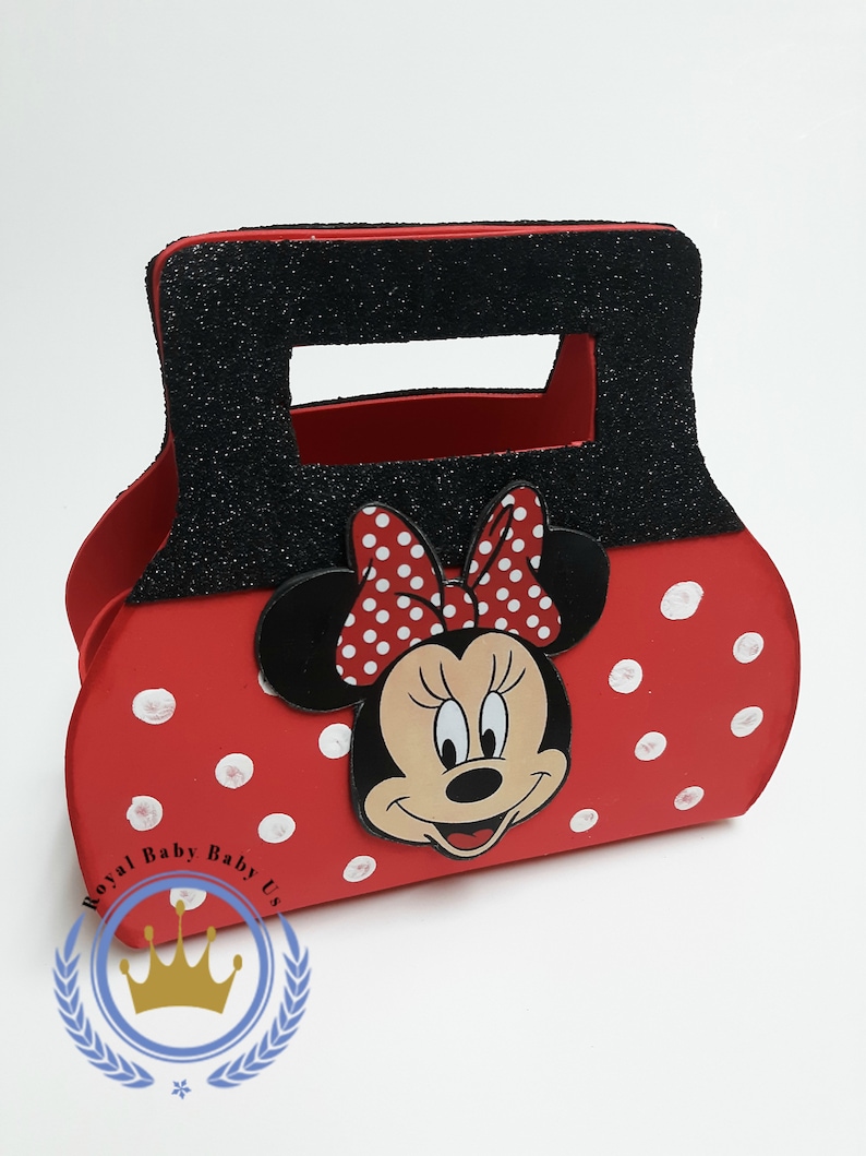 May include: A red Minnie Mouse-themed handbag with white polka dots and a black handle covered in glitter. The bag features a Minnie Mouse face and bow. The text "Royal Baby Baby Us" is printed on the bottom left.