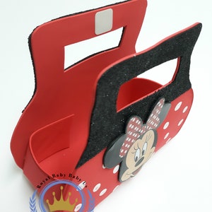 May include: Red Minnie Mouse-themed decorative box with a black glitter handle and accents. The box features a Minnie Mouse face and white polka dots. The logo "Royal Baby Baby Us" is visible on the bottom left.
