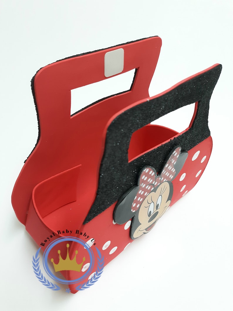 May include: Red Minnie Mouse-themed decorative box with a black glitter handle and accents. The box features a Minnie Mouse face and white polka dots. The logo "Royal Baby Baby Us" is visible on the bottom left.