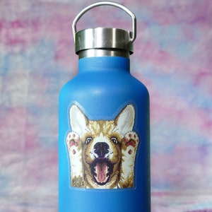 May include: A blue reusable water bottle with a sticker of a smiling corgi dog with its paws up.