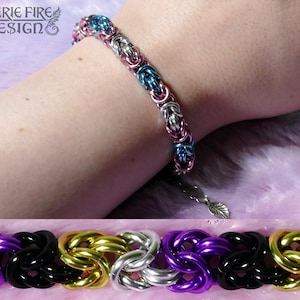 May include: A braided bracelet with alternating colors of purple, black, gold, and silver. The bracelet is made of metal and has a leaf-shaped charm.