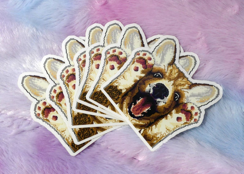 May include: A set of eight stickers featuring a cartoon corgi dog with its paws up in the air. The dog has a brown and white coat and is smiling with its tongue sticking out. The stickers are printed on white paper and have a glossy finish.
