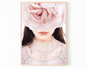 Könnte beinhalten: Eine Frau mit langen braunen Haaren trägt ein weißes Spitzenoberteil. Eine große rosa Blume bedeckt ihre Augen und einen Teil ihres Gesichts.