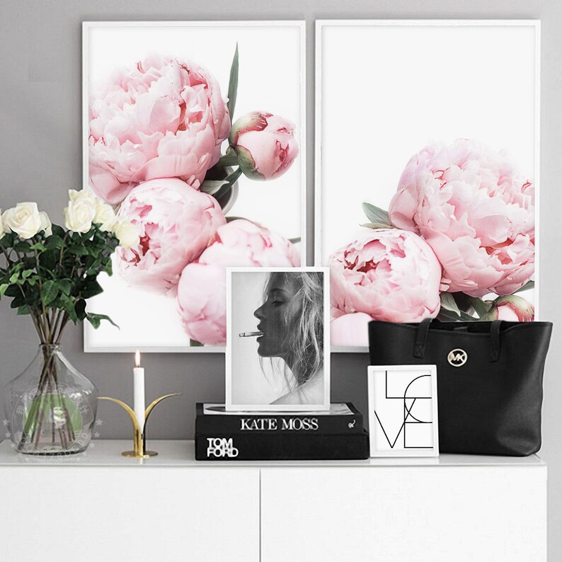 Puede incluir: Dos impresiones enmarcadas de peon&iacute;as rosas, una foto en blanco y negro de Kate Moss, una bolsa de mano negra con un logotipo MK dorado y una impresi&oacute;n enmarcada con la palabra "LOVE" en blanco y negro.