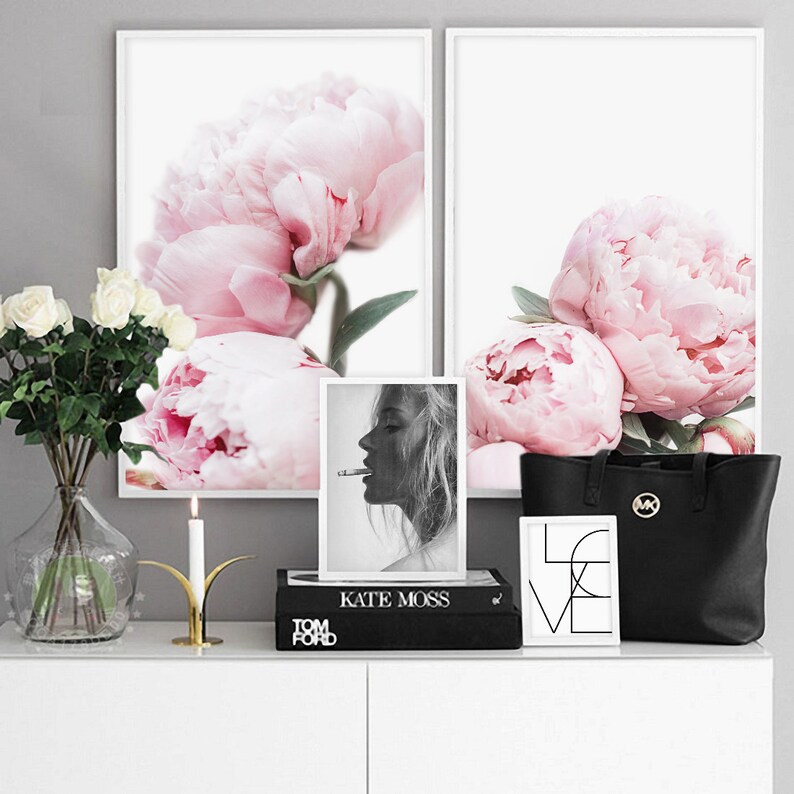 Puede incluir: Dos impresiones enmarcadas de peon&iacute;as rosas, una foto en blanco y negro de Kate Moss, una bolsa de mano negra con un logotipo dorado y una impresi&oacute;n enmarcada de la palabra "LOVE" en blanco y negro.