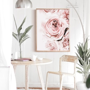 May include: A close-up of a framed print featuring a cluster of soft pink roses. The roses are arranged in a bouquet-like formation, with the petals overlapping and creating a delicate and romantic aesthetic.
