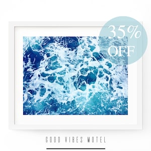 May include: A framed print of a photograph of blue ocean water with white foam. The text "GOOD VIBES MOTEL" is below the image. The text "35% OFF" is in a blue circle in the upper right corner of the image.