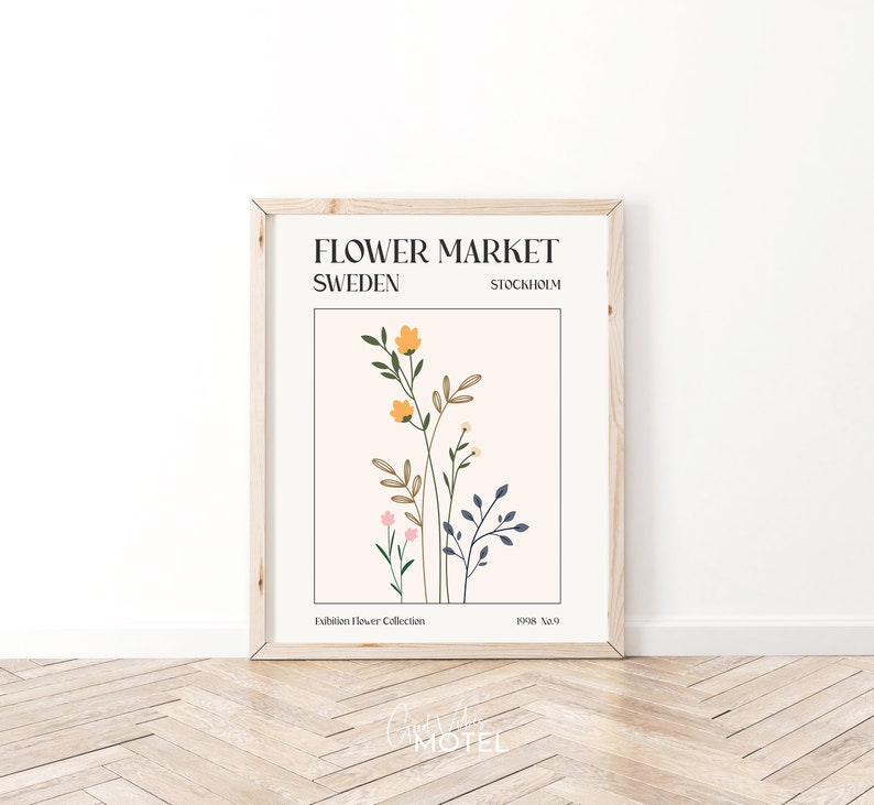 May include: A framed poster with a minimalist design featuring a floral illustration in shades of pink, yellow, and blue. The poster has the text "FLOWER MARKET SWEDEN STOCKHOLM" and "Exhibition Flower Collection 1998 No.9".