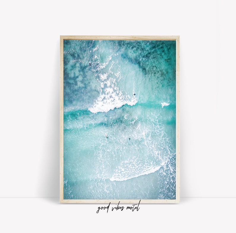 May include: An aerial view of turquoise ocean water with white foamy waves crashing. The water is clear and you can see people swimming and surfing in the waves.