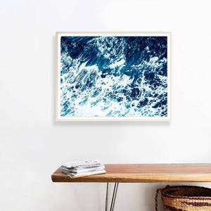 May include: A framed photograph of a close-up of ocean waves with white foam and deep blue water.