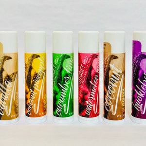 May include: Ten different flavored lip balms in white tubes with colorful labels. The flavors are Peppermint, Unscented, Vanilla, Coconut Pineapple, Cucumber Lime, Watermelon, Coconut, Huckleberry, Iced Pear, and Orange Creamsicle.