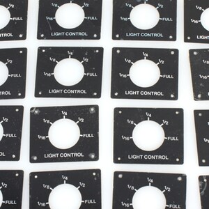 May include: A set of 16 black square light control panels with a round knob and markings for 1/16, 1/8, 1/4, 1/2, and FULL. The panels are labeled "LIGHT CONTROL" and some have "MADE IN JAPAN" printed on them.
