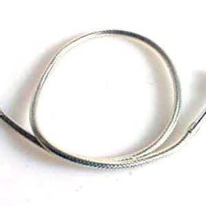May include: A silver-coloured cable with a metal end piece and a small metal knob on the other end. The cable is coiled and appears to be a replacement part for a mechanical device.