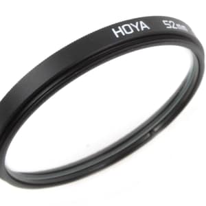May include: A black Hoya 52mm filter for a camera lens.