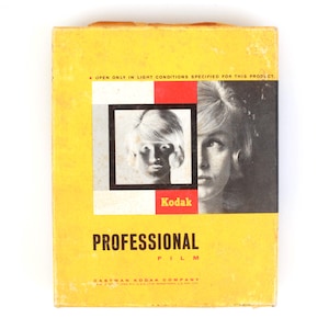 May include: A rectangular yellow Kodak Professional film box featuring black text that reads OPEN ONLY IN LIGHT CONDITIONS SPECIFIED FOR THIS PRODUCT, Kodak, PROFESSIONAL FILM, and EASTMAN KODAK COMPANY. The front displays a black and white portrait.