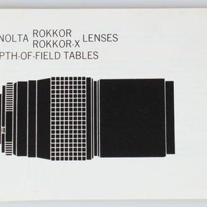 May include: A white booklet with the text "MINOLTA ROKKOR ROKKOR-X LENSES DEPTH-OF-FIELD TABLES". The booklet features a black and white illustration of a camera lens.