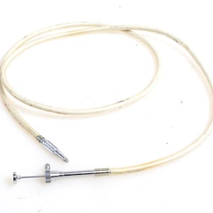 Puede incluir: Un cable médico blanco con una punta de metal plateado y un pequeño accesorio de metal plateado en el extremo del cable.