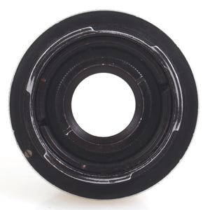 May include: A close-up shot of a black and silver camera lens adapter. The adapter has a circular design with a central opening and a series of concentric rings. The outer ring is silver, while the inner parts are black.