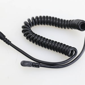 Puede incluir: Cable negro en espiral con dos conectores en ángulo recto.