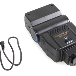 May include: A black Quantaray OB-350A flash unit with a blue ring around the flash head and a black cord with a plug on each end.