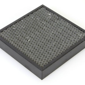 Könnte beinhalten: Ein quadratischer Filter mit schwarzem Rahmen und einem Wabenmuster. Der Filter besteht aus einem silberfarbenen Material.