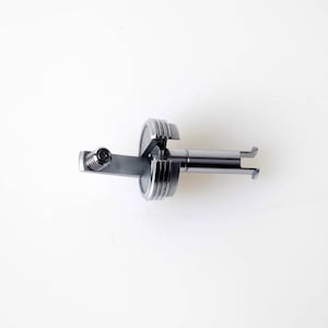 Puede incluir: Un abridor de botellas de vino cromado, con un mecanismo de palanca y un sacacorchos. El abridor tiene un diseño elegante y moderno. Se muestra sobre un fondo blanco. Mide aproximadamente 15 cm de largo.