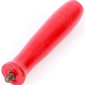 Peut inclure: Une poignée en bois rouge avec une extrémité métallique filetée. La poignée est lisse et de forme arrondie.