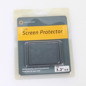 Op de afbeelding: Een transparante plastic verpakking met een schermbeschermer voor een 3,2 inch LCD-scherm. De verpakking is geel en grijs met de tekst "pro master LCD Screen Protector" en "FOR 3.2" 4:3".