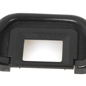May include: A black camera viewfinder eyepiece with a rectangular opening. The eyepiece is made of a soft, rubbery material and is designed to fit over the camera's viewfinder.