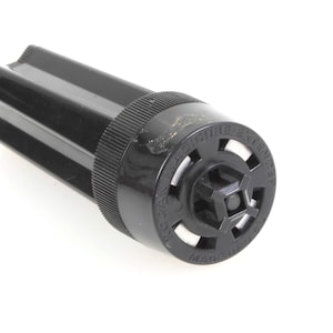 May include: Black plastic sprinkler head with a round, textured top and the words "SECURE EXTENDED LIFE" printed on it.