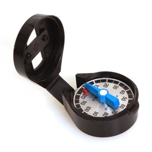 May include: A black compass with a white face and blue needle. The compass is open and the needle is pointing to the north.