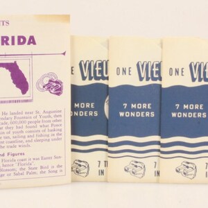 May include: Vintage View-Master reel set featuring Florida. The set includes a booklet with text and illustrations, and several reels with 3D images. The packaging is cream and blue with purple accents.