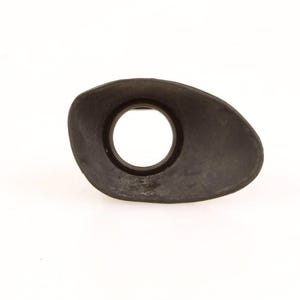 May include: A dark gray, oval-shaped camera viewfinder eyepiece. The eyepiece has a circular opening in the center and is made of a matte material. The item is isolated on a white background.