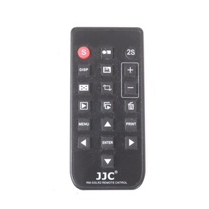 May include: Black remote control with multiple buttons, including a red 'S' button and a plus and minus volume control. The remote has the text 'JJC RM-DSLR2 REMOTE CONTROL' at the bottom.