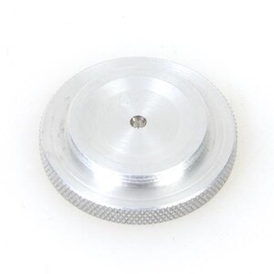 May include: A silver metal cap with a threaded edge and a small hole in the center.