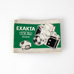 May include: A rectangular paper manual for an Exakta VX IIa 35mm camera. The cover is green with white text reading EXAKTA VX IIa 35mm. It features a black and white illustration of the camera and a separate viewfinder component on the front.