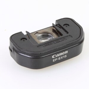 May include: Black Canon EP-EX15 lens cap with a silver lens ring and the Canon logo.
