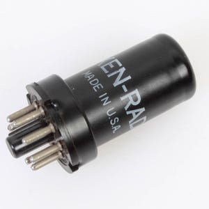 May include: A black Ken-Rad vacuum tube with silver pins. The tube is cylindrical with the text "KEN-RAD MADE IN U.S.A." printed on the side. The tube has a series of pins at the base for connection.