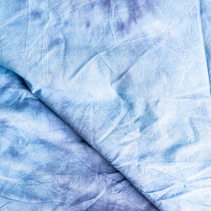 Könnte beinhalten: Nahaufnahme eines blauen und weißen Batik-Stoffes mit einer zerknitterten Textur.
