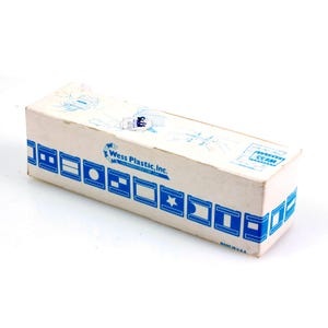 May include: A rectangular cardboard box with a cream-colored background. The box features blue geometric designs and the text "Wess Plastic, Inc." The words "Made in U.S.A." are printed on the bottom right corner.