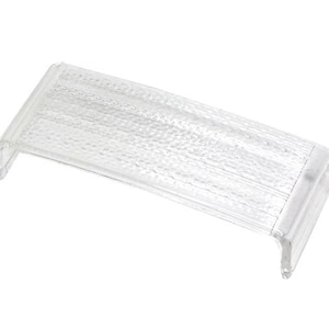 May include: A clear, rectangular plastic object with a textured surface and curved edges. The object is transparent and appears to be a protective cover or a small display stand. The design is simple and functional.