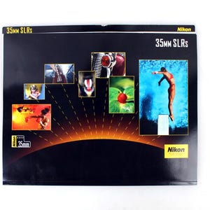 May include: A black Nikon advertisement featuring the text "35mm SLRs" and several small images. One image shows a diver in mid-air. The Nikon logo is visible in the bottom right corner.