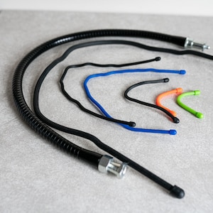 以下が含まれることがあります： 異なる長さの接続部が付いた、柔軟性のある黒と色のチューブのセット。チューブは耐久性のある素材で作られており、柔軟性があり、曲げることができます。チューブは、自動車、産業、医療など、さまざまな用途に最適です。