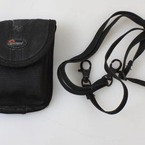 Estuche vintage para cámara Lowepro con correa: almacenamiento compacto y protector para el cuerpo de la cámara, lentes y accesorios.