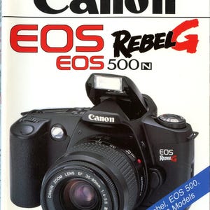 May include: A Magic Lantern Guides book cover for the Canon EOS Rebel G and EOS 500N camera. The cover features a black Canon SLR camera with a 35-80mm zoom lens and a raised flash. Text includes the title, authors Bob Shell and Heiner Henninges.