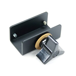 May include: Black metal bracket with a black knob and a brown felt pad. The bracket is designed to hold a microphone or other equipment.
