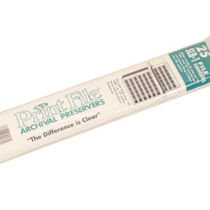 Może przedstawiać: Opakowanie archiwizatorów Print File, zawierające 25 wieszaków na pliki SLB-1. Opakowanie jest białe z zielonym i czarnym tekstem, w tym frazą "The Difference is Clear."