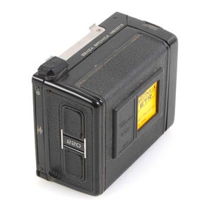 Op de afbeelding: Een zwarte en zilveren 220 Zenza Bronica camera voor middelformaat met een geel filmtellervenster.