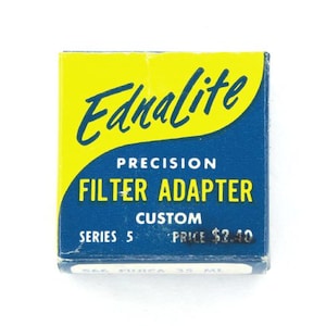 May include: A vintage Ednalite Precision Filter Adapter box. The box is blue and yellow with the words "Ednalite" and "Filter Adapter" in a stylized font. The box also has the text "Series 5" and "Custom".